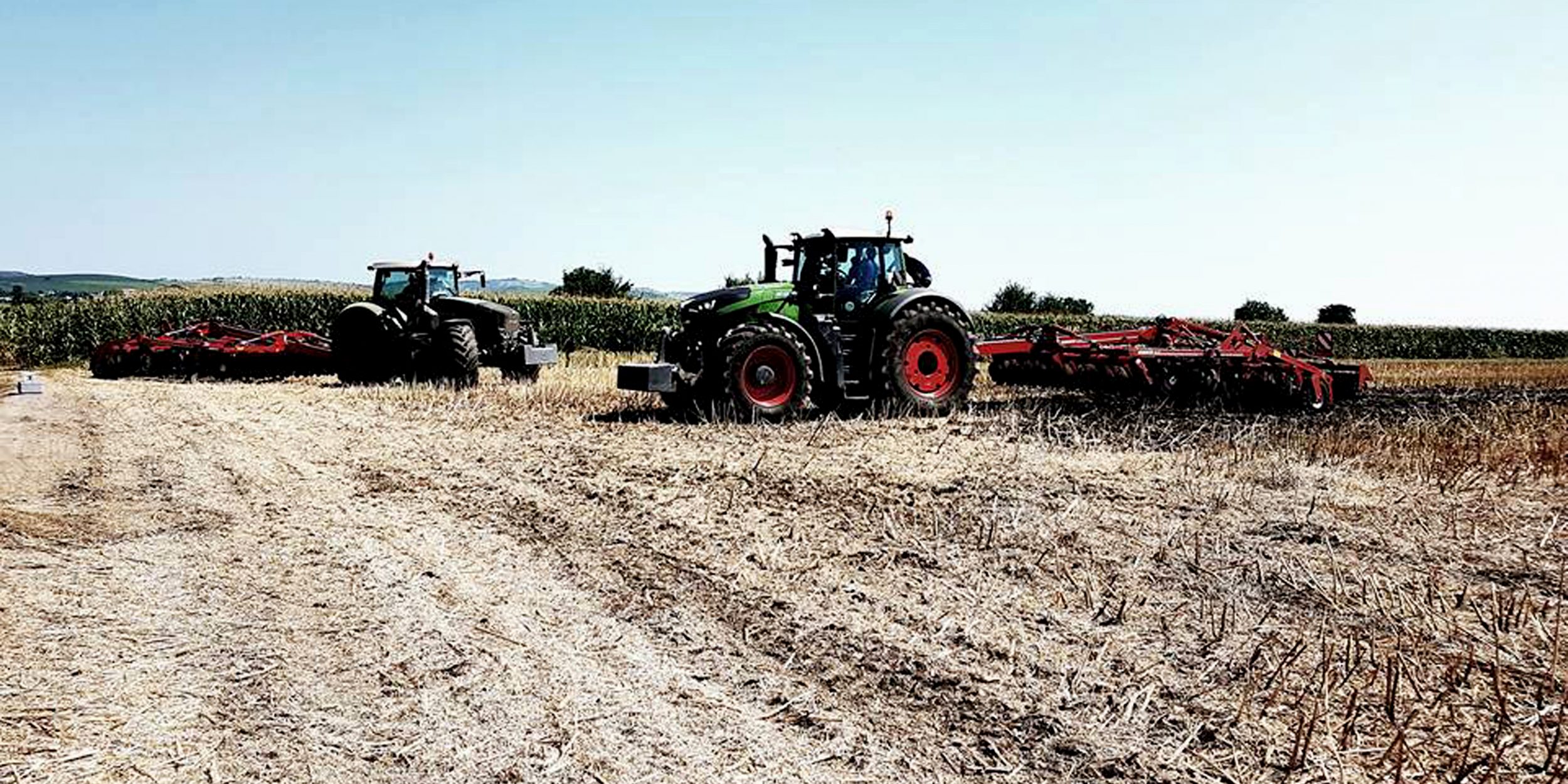 Doua tractoare cu prasitoare pe suprafata de camp